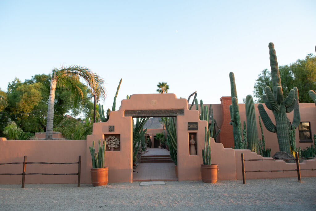 an adobe style entry gate welcoming travelers into a dude ranch in arizona