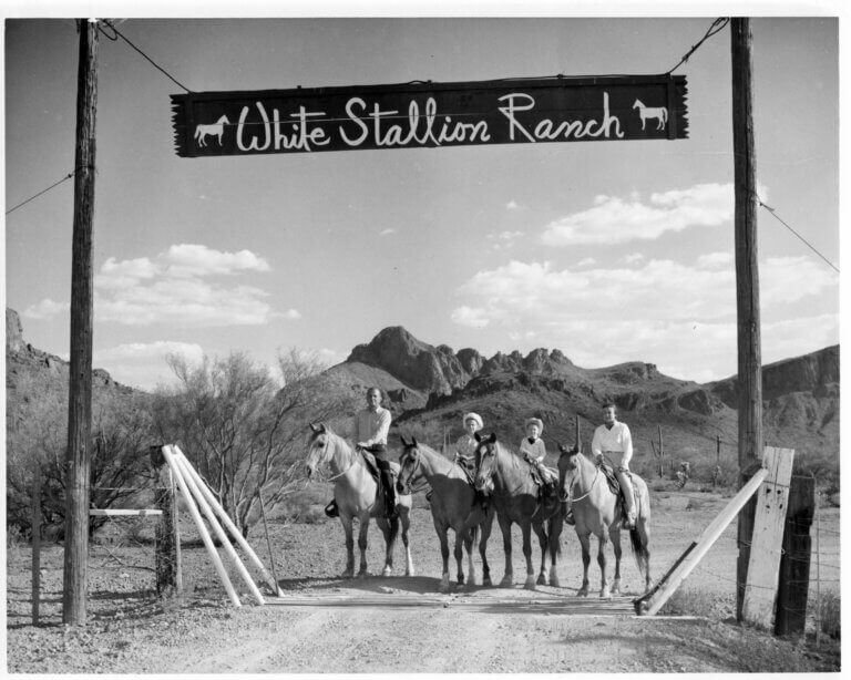 White Stallion Ranch Back in the day, with the True Family mounted on Horseback under the White Stallion Ranch Sign a Dude ranch in Arizona